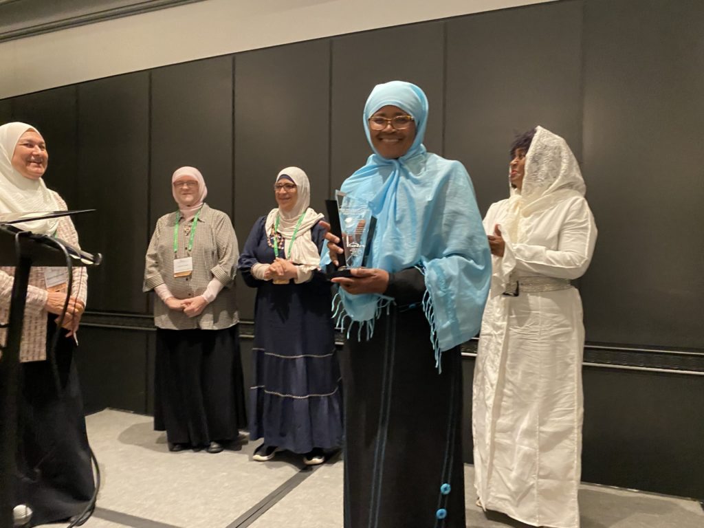 Dr. Patricia standing with award