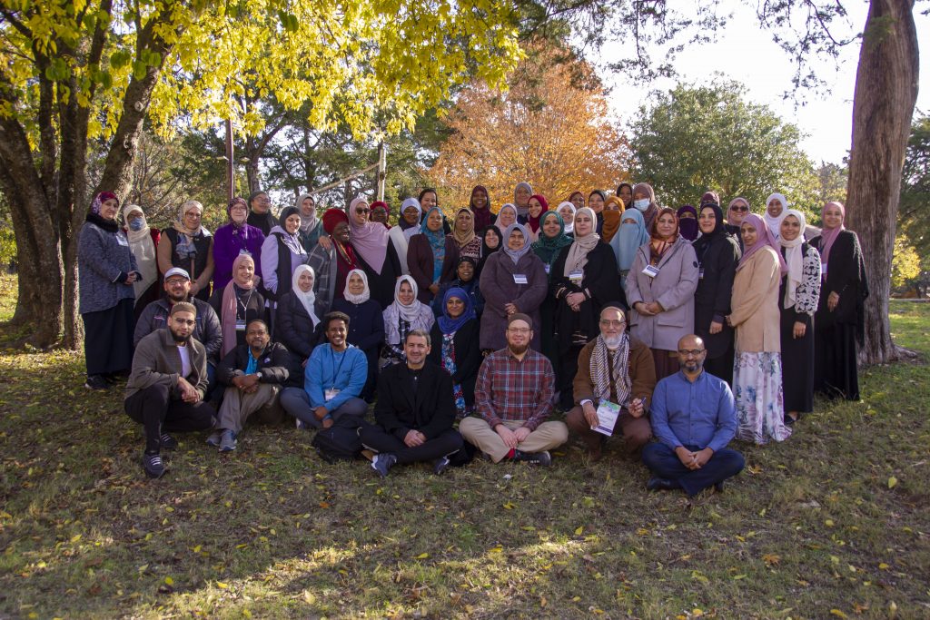 Group picture of attendees amidst trees
